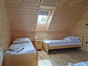 Posteľ alebo postele v izbe v ubytovaní DOMEK POD CZEREMCHĄ