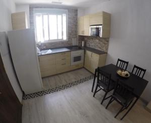 una pequeña cocina con mesa y comedor en Apartamento cristo de la yedra con parking, en Granada