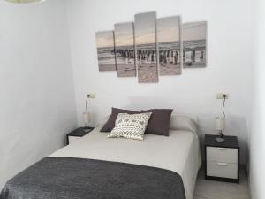 1 dormitorio con 1 cama con 4 cuadros en la pared en Apartamento cristo de la yedra con parking, en Granada