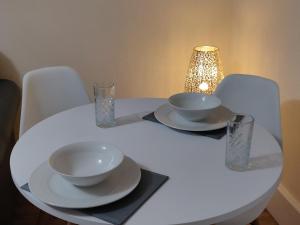 un tavolo bianco con due ciotole e bicchieri sopra di Marmaduke Apartments - Entire Apartment Close to City Centre a Liverpool