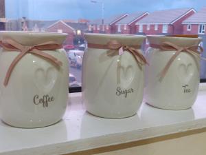 three white jars sitting on a window sill at Marmaduke Apartments - Entire Apartment Close to City Centre in Liverpool