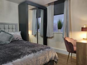a bedroom with a bed and a window with a chair at Marmaduke Apartments - Entire Apartment Close to City Centre in Liverpool