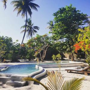 a swimming pool in a resort with palm trees at Michamvi Spirit Lodge in Michamvi