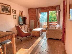 a living room with a television and a table and chairs at Bel appartement au calme vue vallée in Sainte-Foy-Tarentaise