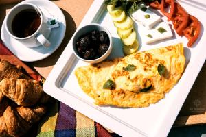 a plate with an omelet and a cup of coffee and bread at 4- you Family in Metamorfosi