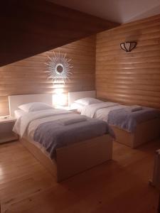 a bedroom with two beds and a light on the wall at Sanli in Mestia