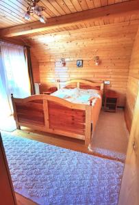 una camera da letto con un grande letto in una camera in legno di Cabanele FloriCrin - Cabana 1 a Cluj-Napoca