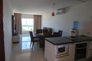 a kitchen and living room with a table and chairs at Terra Nostra Residence in Porto De Galinhas
