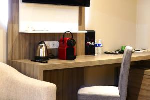 a room with a counter with a red appliance on it at Contact Hôtel Le Provençal Bordeaux Lac in Bordeaux