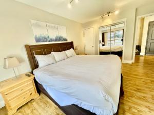 a bedroom with a large white bed and a night stand at Best ski in ski out condo at Whistler in Whistler