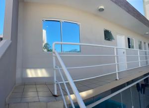 - un balcon avec une échelle à côté d'une piscine dans l'établissement AP frente à praça bem localizado, à São José