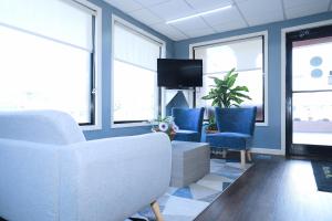 un soggiorno con divano bianco e sedie blu di Super 8 by Wyndham Marion NC a Marion