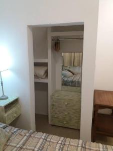 - une chambre avec un lit, une commode et un miroir dans l'établissement Dpto Microcentro Rosario, à Rosario