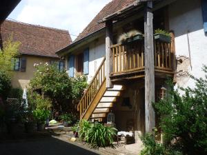 uma casa com uma varanda de madeira ao lado em Les hirondelles em Wangen
