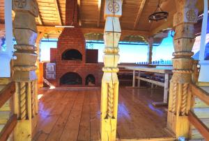 Cette grande chambre en bois dispose d'une cheminée en briques. dans l'établissement Cabanele FloriCrin - Cabana 2, à Mărişel