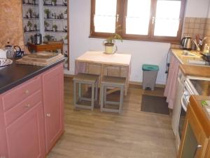 a kitchen with pink cabinets and a table in it at Les hirondelles in Wangen