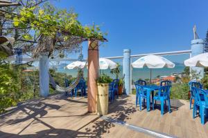 a patio with blue chairs and tables and umbrellas at Mediterrâneo in Biguaçu