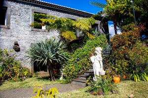 una estatua frente a un edificio con plantas en Vila Afonso, en Estreito de Câmara de Lobos