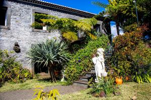 a statue in front of a building with plants at Vila Afonso in Estreito de Câmara de Lobos