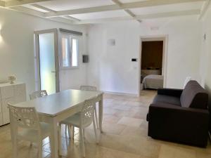 a living room with a table and a couch at Fernanda's House - Incantevole con idromassaggio su richiesta in Pulsano