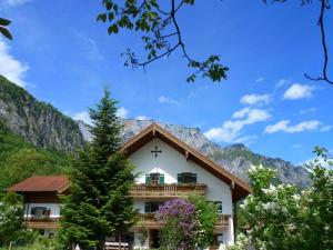 a building with a balcony with mountains in the background at Gästehaus Pfeffererlehen in Marktschellenberg