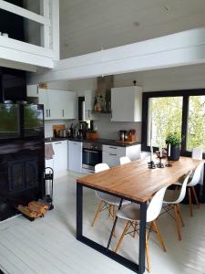 a kitchen with a wooden table and a fireplace at Villa Laiskajaakko in Vimpeli
