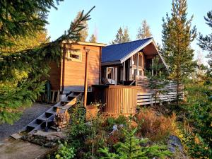a wooden house with a staircase leading to it at Villa Laiskajaakko in Vimpeli