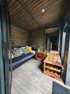 a room with a bed and a table on a deck at Villa Laiskajaakko in Vimpeli +43 photos