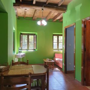 Pokój z zielonymi ścianami, stołem i kanapą w obiekcie Valles del Narcea, Apartamentos Rurales w mieście Cangas del Narcea