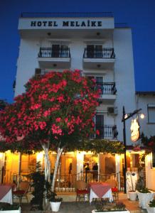 a hotel malete with a tree in front of it at Melaike Hotel in Foça