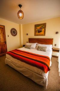 a bedroom with a large bed with a striped blanket at Hostal Geosol in Antofagasta