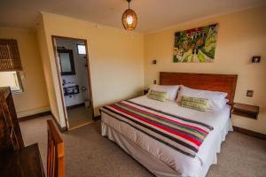 Un dormitorio con una cama con una manta de colores. en Hostal Geosol, en Antofagasta