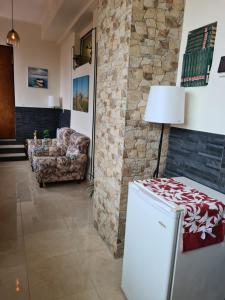 a living room with a refrigerator and a stone wall at Domus Lace in Messina