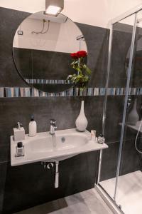 uma casa de banho com um lavatório branco e um espelho. em NAPOLI IN BLU MAISON em Nápoles
