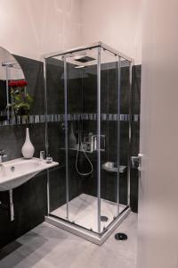 a shower with a glass enclosure next to a sink at NAPOLI IN BLU MAISON in Naples