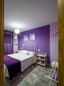 um quarto roxo com uma cama e uma parede roxa em La Huerta - VuT AV187- para 10 personas em Poyales del Hoyo