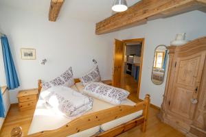 ein Schlafzimmer mit einem Holzbett mit Kissen darauf in der Unterkunft Apartment Bügl Grond 124 in Scuol