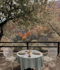 een tafel met twee stoelen en een tafel met borden erop bij Guest House Ktona in Dardhë