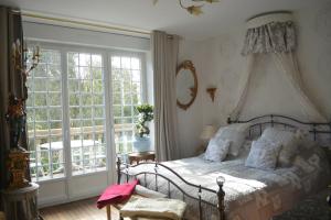 - une chambre avec un lit et une grande fenêtre dans l'établissement La Villa Saint Martin, à Cournon