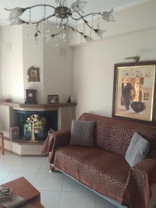 uma sala de estar com um sofá castanho e uma lareira em Sweet luxury apartment Peraia em Perea