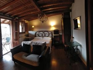 a bedroom with a bed and a couch and a chair at Alojamientos La Herrera in San Esteban de la Sierra