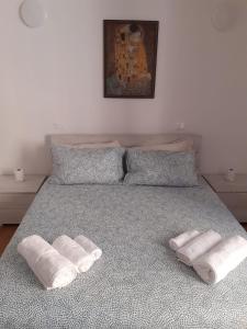 a bed with two pillows and two towels on it at Appartamento turistico I portici in LʼAquila