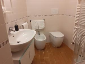 een witte badkamer met een wastafel en een toilet bij Appartamento turistico I portici in LʼAquila