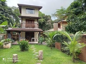 a house with a lawn in front of it at Casa dos Coqueiros Praia de Camburi, condomínio in Camburi