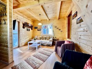 a living room with a couch and a table at Chatka vo Vysokých Tatrách in Tatranska Strba