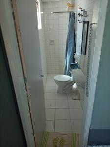 a small bathroom with a toilet and a sink at Quarto Familiar Aconchegante in Recife
