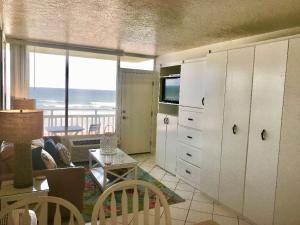 a living room with white cabinets and a view of the ocean at Beachfront Bliss - Suite at Symphony Beach Club in Ormond Beach