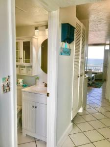 a bathroom with a sink and a mirror at Beachfront Bliss - Suite at Symphony Beach Club in Ormond Beach