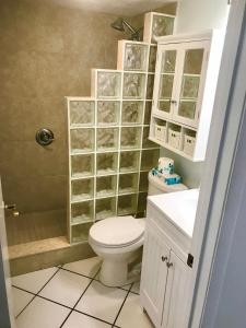 a bathroom with a toilet and a sink and a shower at Beachfront Bliss - Suite at Symphony Beach Club in Ormond Beach