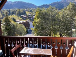 a balcony with a table and mountains in the background at le coup de coeur in Les Houches